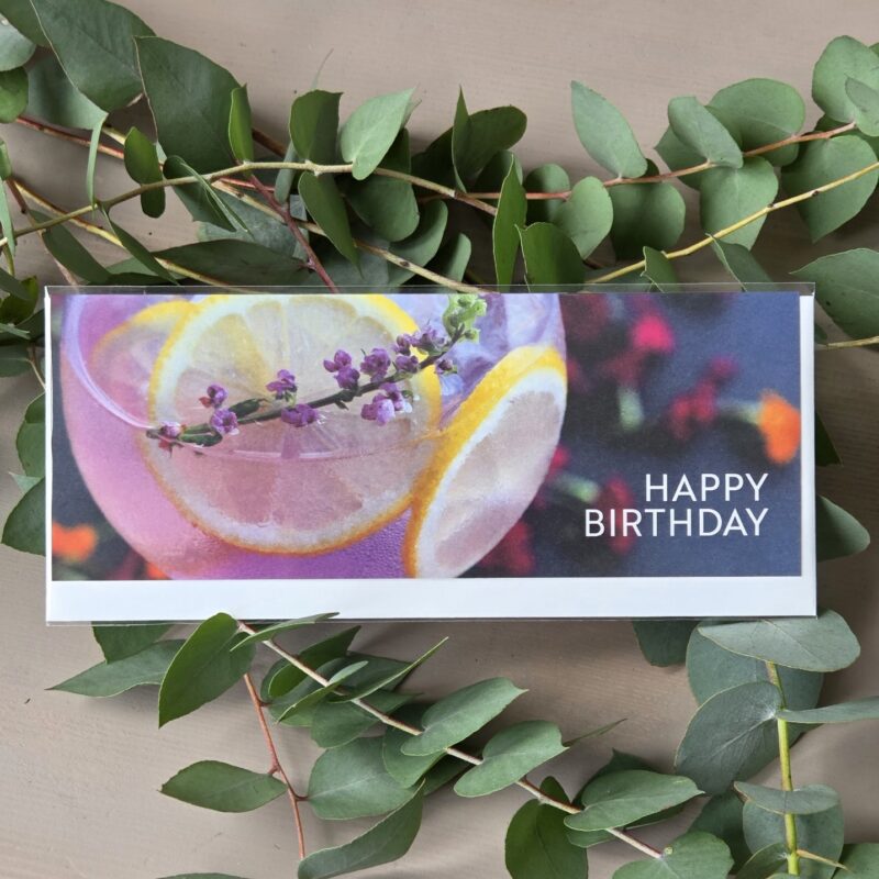 Geburtstagskarte mit Cocktailbild, Zitrone und Lavendel, umrahmt von Eukalyptuszweigen, Text: Happy Birthday.