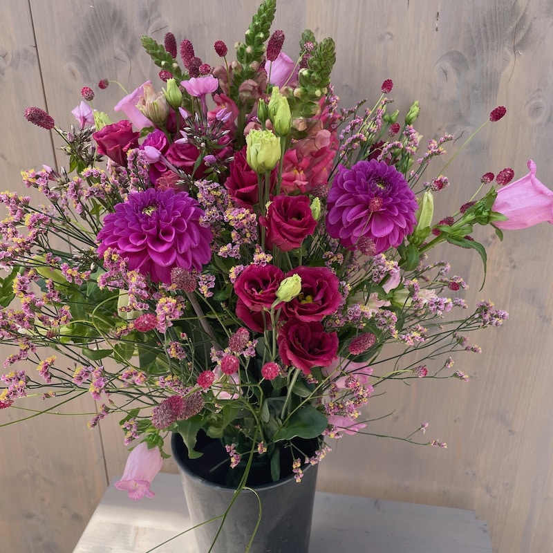Bunter Blumenstrauß mit rosa und lila Blüten in einer Vase auf hellem Hintergrund. Ideal für Dekoration.